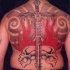 Le tatouage sur le dos avec une crâne et une épée en flammes