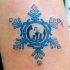 Tatuaje en tinta azul con símbolo de planeta en la copa de nieve