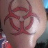 Símbolo del peligro biológico tatuaje en tinta roja