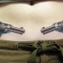 Tatuaggio grande colorato sulla pancia due pistole