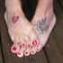 Tatuajes en los pies, el corazón y una inscripción