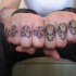 Quatre fleurs et quatre crânes tatouage sur les phalanges