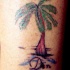 Tatuaje en la pierna, palmera cerca del agua