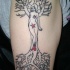 Tatuaggio grande sul braccio la ragazza appoggiata sull'albero con le radici