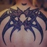 Araña estilo tribal tatuaje en la parte superior de la espalda