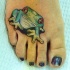 Bonito tatuaje la rana verde en el pie