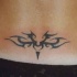 Pequeño signo tribal tatuaje en el bajo de la espalda