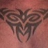 Tatuaje signo tribal en la parte superior de la espalda