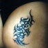 Signo estilo tribal en tinta negra en la nalga