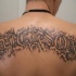 Tatuaggio sulla schiena la scritta grande calligrafica