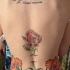 Le tatouage de haut du dos avec un clé de l'amour au dessous des fleurs