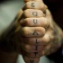 Tatuaje en los nudillos, inscripción vertical, letras finas