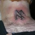 Tatuaje en tinta negra el signo del viking en el cuello