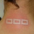 Tatuaje tres cuadrados en tinta blanca en parte trasera del cuello