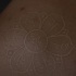 Tatuaje la flor con los símbolos de yoga en tinta blanca
