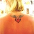 Pequeño tatuaje el corazón rojo con las alas en la espalda