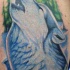 Un beau loup bleu en hurlant dans le tatouage de forêt