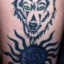 Loup aux yeux verts le tatouage avec le soleil bleu