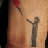Tatuaggio sul polso il bimbo piccolo con pallone in stile Banksy art