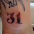 Tatuaggio sul polso il numero 31 & le note