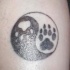 Tatuaje Yin yang con las huellas del animal en negro y blanco