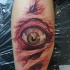 Tatuaje en el brazo, piel rasgada con un ojo asustado