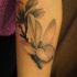 Tatuaje en el antebrazo,
dos flores simples en la ramita