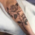 Tatuaje en el antebrazo, rosa realista
con espinas en el tallo