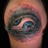 Tatuaje en el brazo, ojo tremendo con dos pupilas