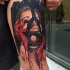 Tatuaje en el brazo,
mujer asustada en máscara con manos en sangre