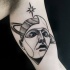 Tatuaggio bicipite terrificante stile blackwork della testa mistica con pianeta e stella di Michele Zingales