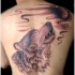Tatuaggio impressionante sulla schiena la testa del lupo che ulula