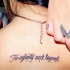 Tatuaje en la espalda alta, 
inscripción en inglés, tinta negra