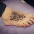 Tatuaje en el pie,
rama gris de flores