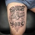 Tatuaje en el muslo, 
emblemas de letras lindas, tinta negra