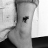 Tiny black ink ankle tattoo of homemade like elk