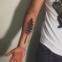 Winziges schwarzes Unterarm Tattoo mit Baum und Auge