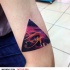 Triangle shaped colored arm tattoo stylized with Eye of Horus and space