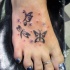 Tatuaje de mariposas tribales en el pie