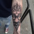 Tribal Stil schwarze Maske Tattoo am Unterarm  mit Dreieck und Symbolen und Bäumen