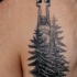 Typical black ink chest tattoo of big stone statue with forest