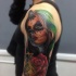 Typical multicolored shoulder tattoo of Mexican woman portrait and flower