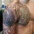 Typical tribal tattoo on chest and shoulder with various sculptures