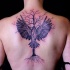Tatuaje en la espalda, árbol seco con cuervo con alas extendidas, colores oscuros
