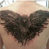 Tatuaje en la espalda, cuervo alucinante de tinta negra