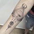 Tatuaje en el antebrazo, cerebro humano en el triángulo y símbolos misteriosos