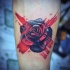 Tatuaje en el antebrazo, rosa negra con rayas rojas