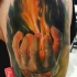 Illustrative style colored shoulder tattoo of man with burning hand