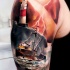 Illustrative style colored shoulder tattoo of sailing ship with lighthouse