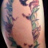 Illustrative style colored shoulder tattoo of small rat with flowers